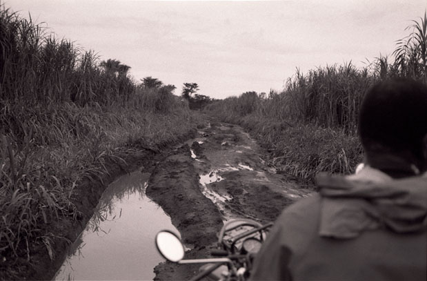 On the back of the bike on the only route to Aba, Eastern Congo, an area held by Joseph Kony's LRA rebels. The only way there is by bike through one hundred miles of mud in the pouing rain.     —Candace Scharsu, August 2009 